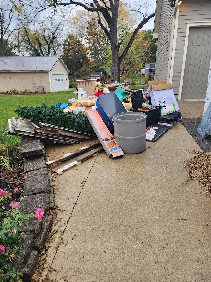 Dumpster being loaded with debris for Estate Cleanout Dumpster Rental in Muscle Shoals